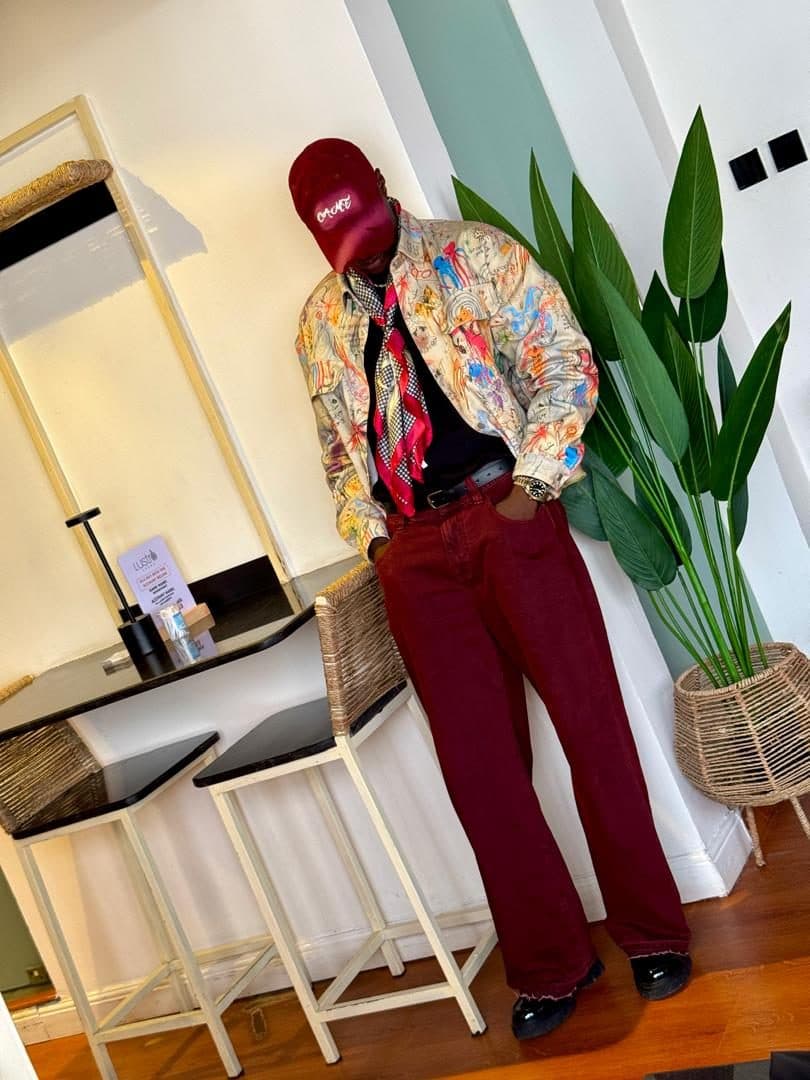 Printed shirt and silk scarf over burgundy trousers